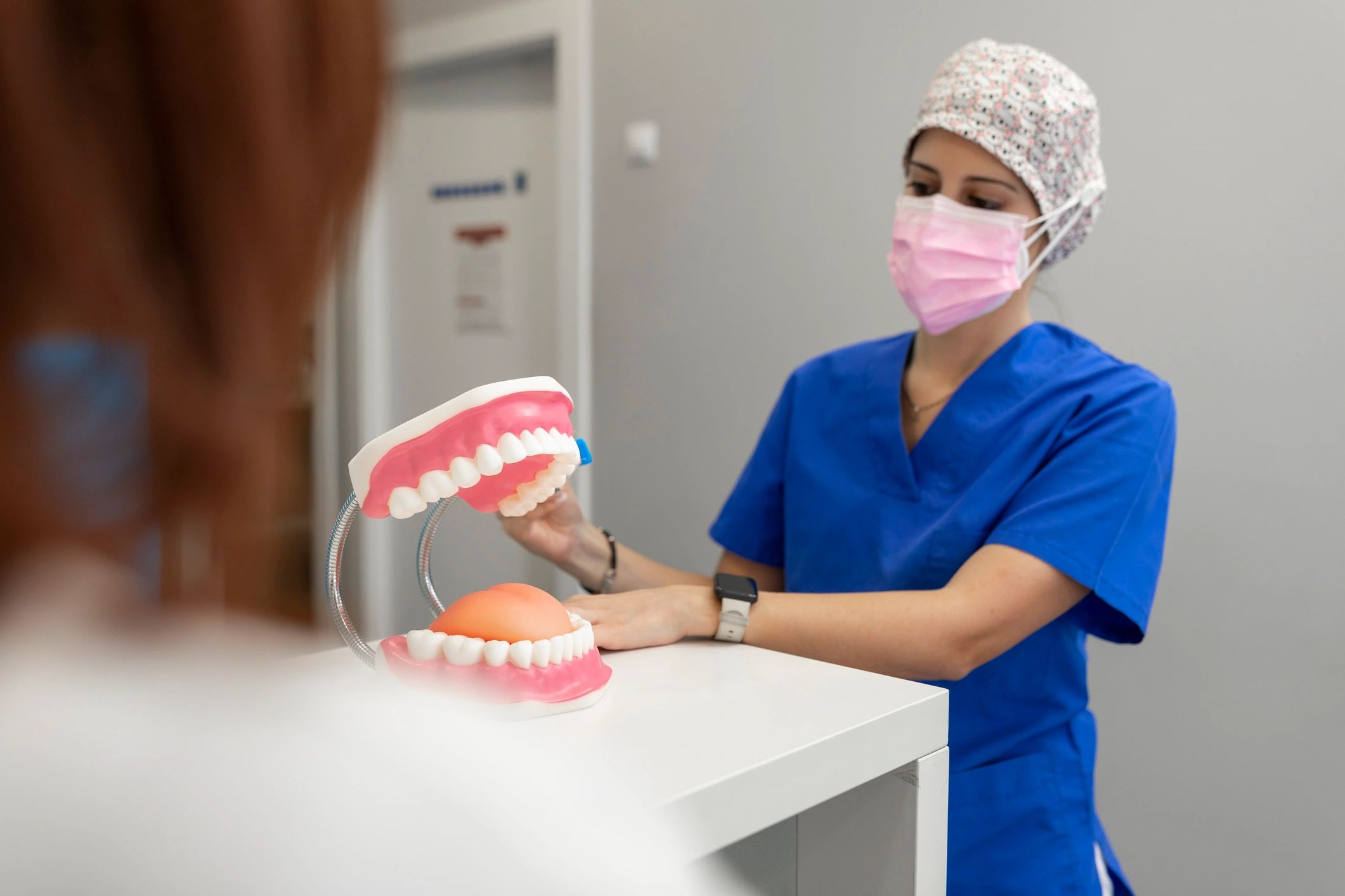 Dental professional demonstrating brushing technique to a patient