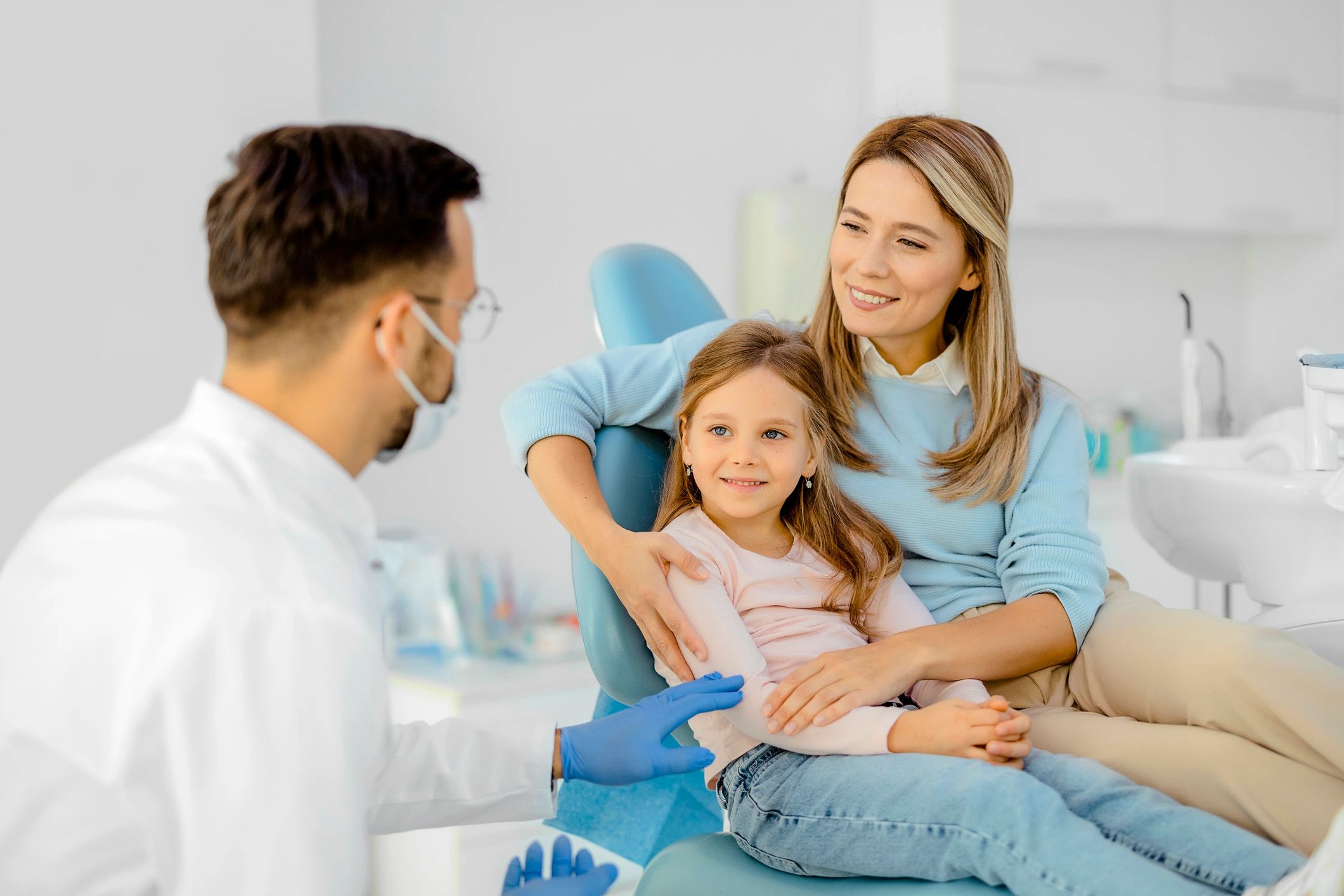 Dentist speaking with a parent and child in a dental office