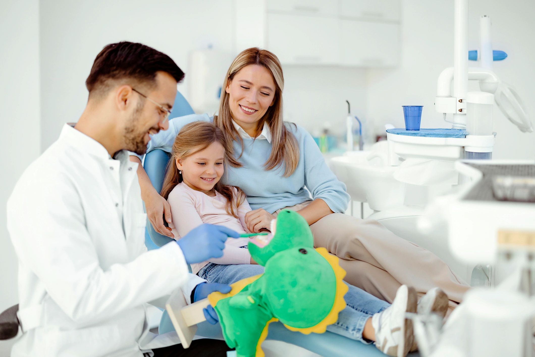 Dentist educating a child about brushing teeth