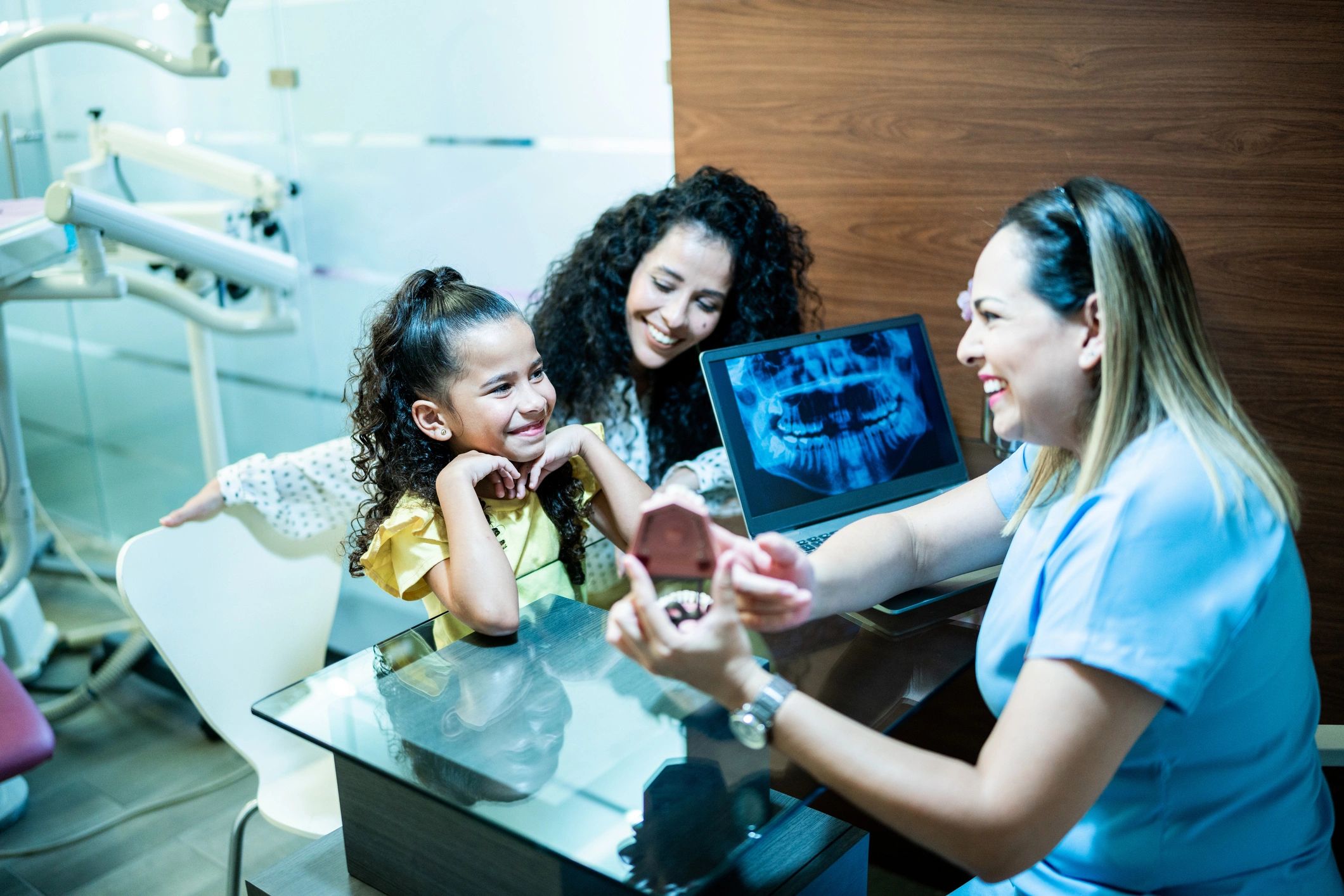Dentist speaking with a mother and child in a dental office