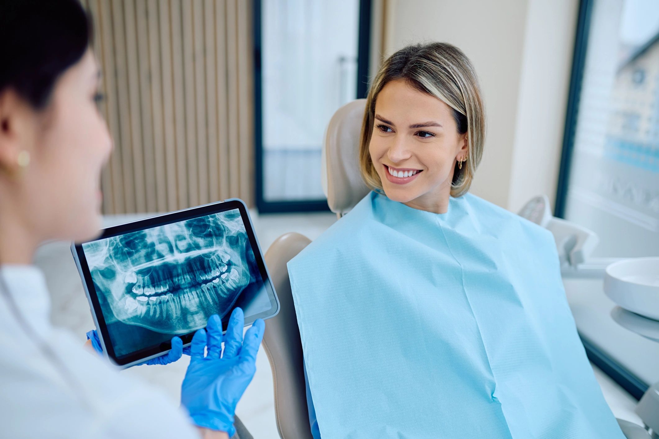 Dentist reviewing a dental x-ray with a patient in a modern clinic